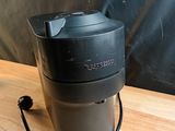 une cafetière noire posée sur une table en bois