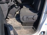the interior of a car with the door open and the driver ' s seat down