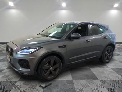 un SUV Jaguar gris garé dans un garage au sol carrelé
