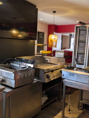une grande cuisine avec de nombreux appareils électroménagers posés sur le plan de travail