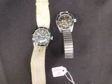 deux montres et un bracelet de montre posés sur un fond noir