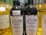 plusieurs bouteilles de vin sont alignées sur une étagère dans un magasin