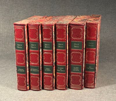 four red books are lined up in a row on a gray surface
