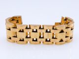 gros plan d'un bracelet en or sur une surface blanche