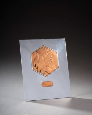 l'image d'une petite pièce d'argent et d'or posée sur une surface blanche