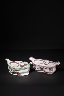 a pair of pink and white porcelain dishes with floral designs