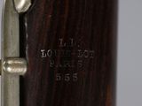 the bottom part of a bassoon with a wooden body and brass fittings