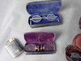 three pairs of glasses in a case and a pair of glasses in a case