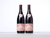 two bottles of red wine sitting on top of a table