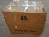 cardboard box sitting on the ground with a dining side chair on it