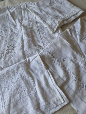 a white table cloth with embroidered designs on it