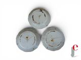 three white plates with rust on them sitting on a white surface