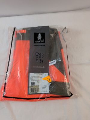 un sac de vêtements posé sur un lit, muni d'une étiquette