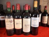 several bottles of red wine are lined up on a table