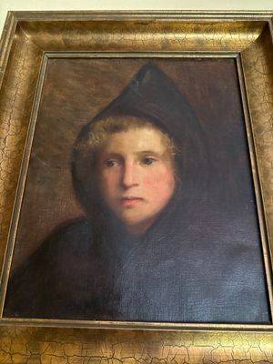 portrait d'un jeune garçon coiffé d'une capuche noire, encadré d'un cadre doré