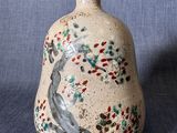 un petit vase orné d'un oiseau sur fond bleu