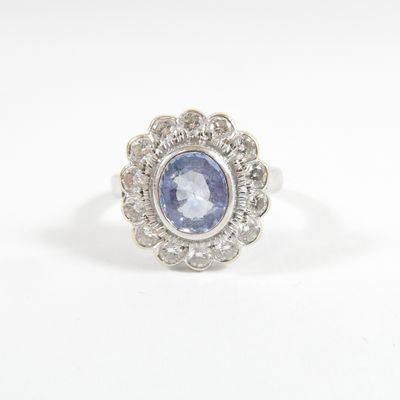 a close up of a ring with a blue sapphire surrounded by white diamonds