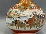 a vase with a painting on it sitting on a table