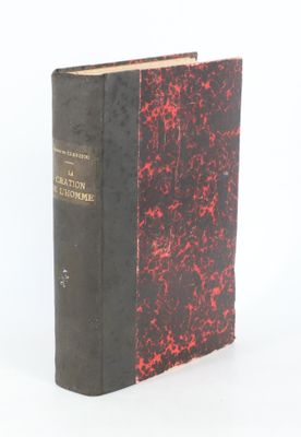 un vieux livre posé sur une table blanche à côté d'un mur blanc