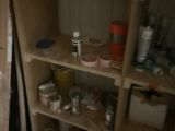 a cat that is sitting on the floor next to a shelf