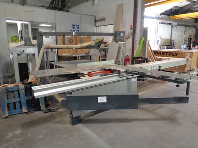 a machine that is cutting a piece of wood in a workshop