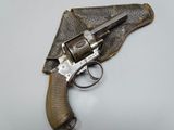 an old revolver with a leather case on a white surface