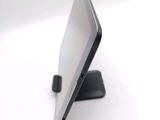 a tablet computer sitting on a stand on a white surface
