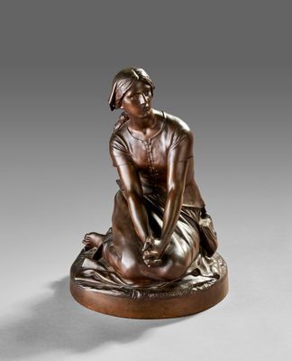 a bronze statue of a woman sitting on top of a pillow