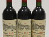 three bottles of red wine sitting on top of a white table