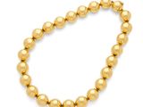 un bracelet en perles dorées muni d'un fermoir à boule