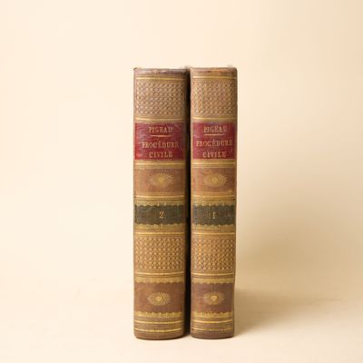 deux vieux livres sont empilés l'un sur l'autre sur une surface blanche