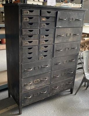une armoire noire avec de nombreux tiroirs, dans un magasin