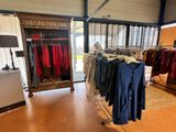a lot of clothes hanging on a rack in a store