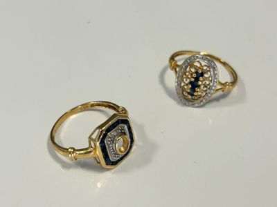 deux bagues en or serties de diamants et de saphirs sur un fond blanc