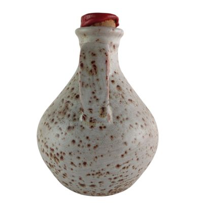 un petit vase blanc parsemé de taches marron
