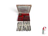 a silverware set in a red case on a white surface