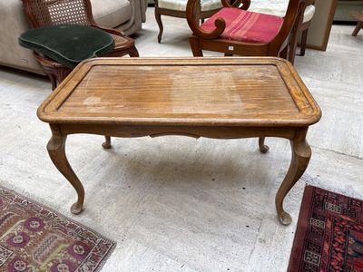 Table basse en bois naturel mouluré, le plateau cabaret  reposant sur 