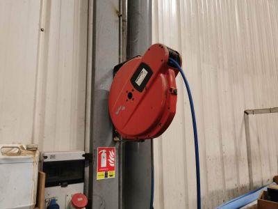 un tuyau rouge fixé sur le côté d'un immeuble