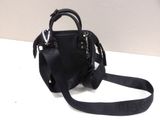 a black purse with a strap on a white table