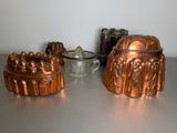 many different types of cake pans sitting on a table