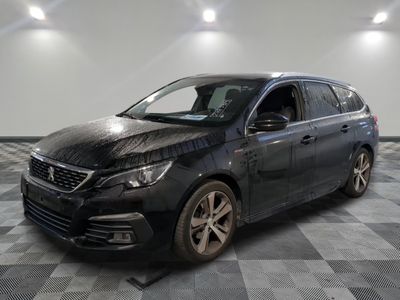 la voiture noire est garée sur un sol en damier dans le garage