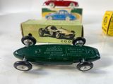 a green toy car sitting next to a box of yellow boxes