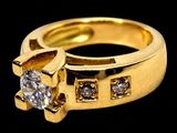 a yellow gold ring with a single diamond on the side