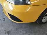 a close up of a yellow car parked in a garage
