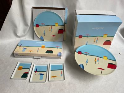 une boîte de sous-verres et une assiette ornée d'une illustration représentant une scène de plage