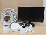 a desk with a monitor, mouse, and other electronics on it