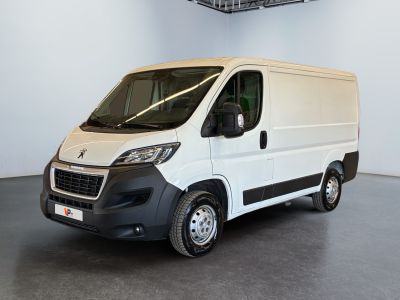 La camionnette blanche est garée dans une grande pièce, avec un panier au-dessus.