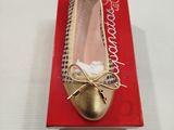 Quelqu'un porte une paire de chaussures dorées ornées de nœuds.