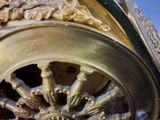 a close up of a clock with a wheel on it