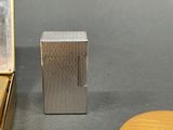 a silver lighter sitting on a table next to a mirror
